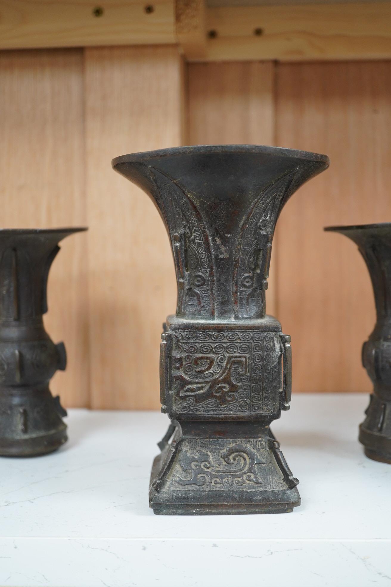 A pair 17th/18th century Chinese archaistic bronze gu vases, and a similar square vase, fanggu, Ming dynasty, tallest 18cm. Condition - poor to fair